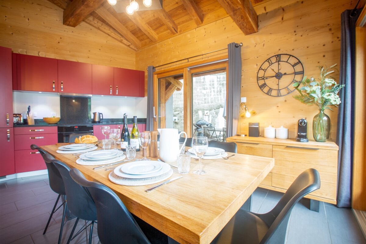 A kitchen with a clock on the wall that has roman numerals