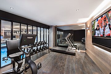 A gym with a treadmill and a tv with the number 14 on it