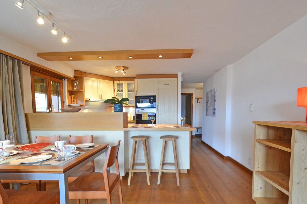 A kitchen and dining area with a table and chairs