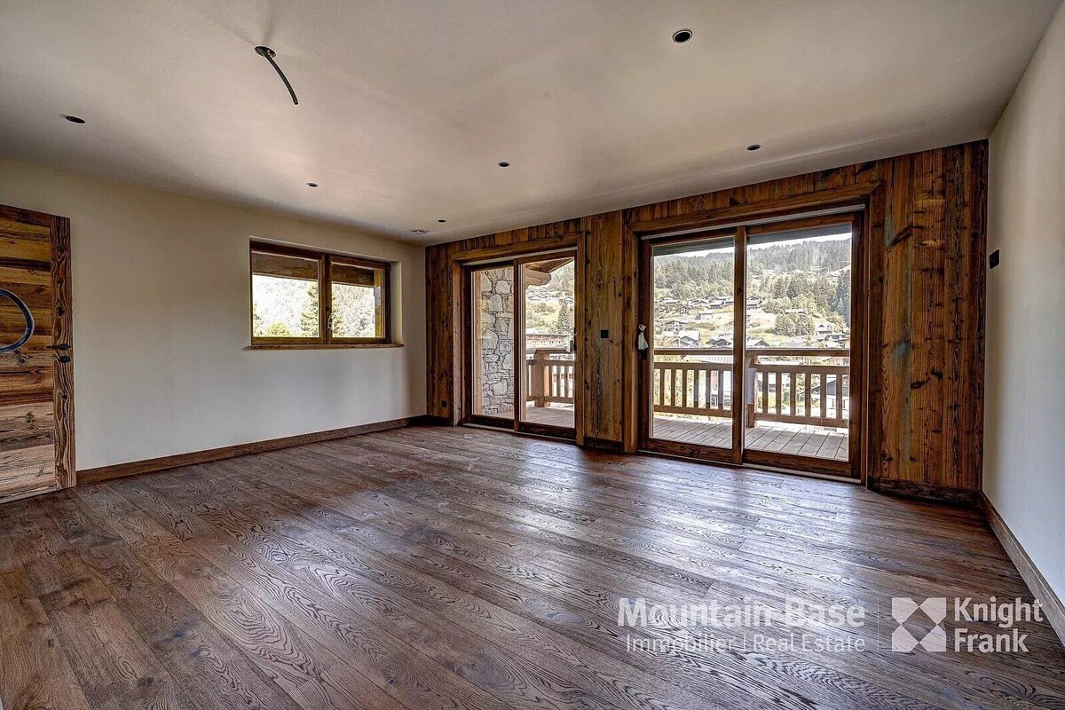 An empty room with sliding glass doors and a sign that says mountain base