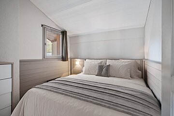 A small bedroom with a bed and a window