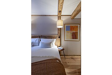 A bedroom with a bed and a painting on the wall