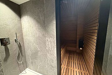 A bathroom with a shower and a wooden sauna