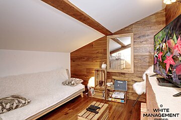 A living room with a flat screen tv and a rental designer logo