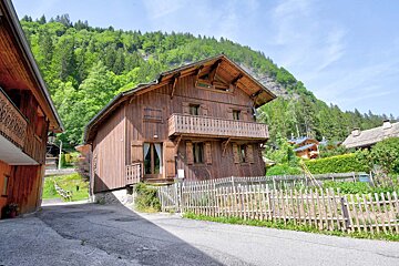A wooden house with a fence in front of it