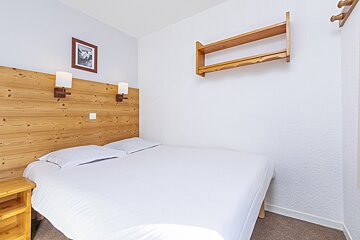 A bedroom with a bed and a picture on the wall