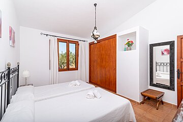 A bedroom with two beds and a mirror