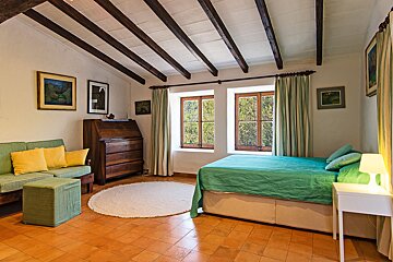 A bedroom with a bed a couch and a desk