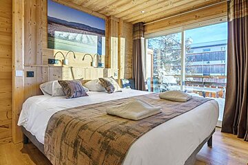 A bedroom with a large bed and a large window