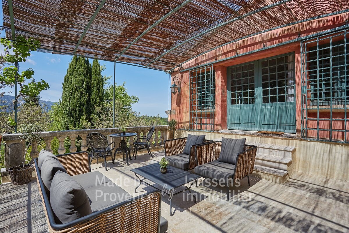 A patio with wicker furniture and a table that says made in provence