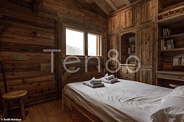 A bedroom with a bed and the word ten80 on the wall