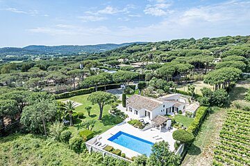An aerial view of a house with a large swimming pool