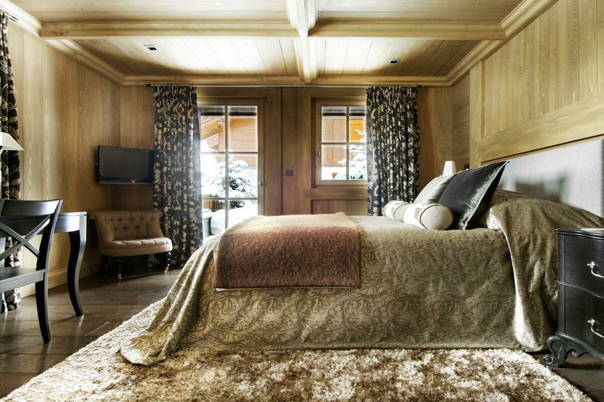 A bedroom with a bed and a television on the wall