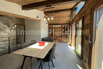 A dining room with a table and chairs and a sign that says immobilier.com