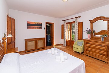 A bedroom with a large bed and a dresser