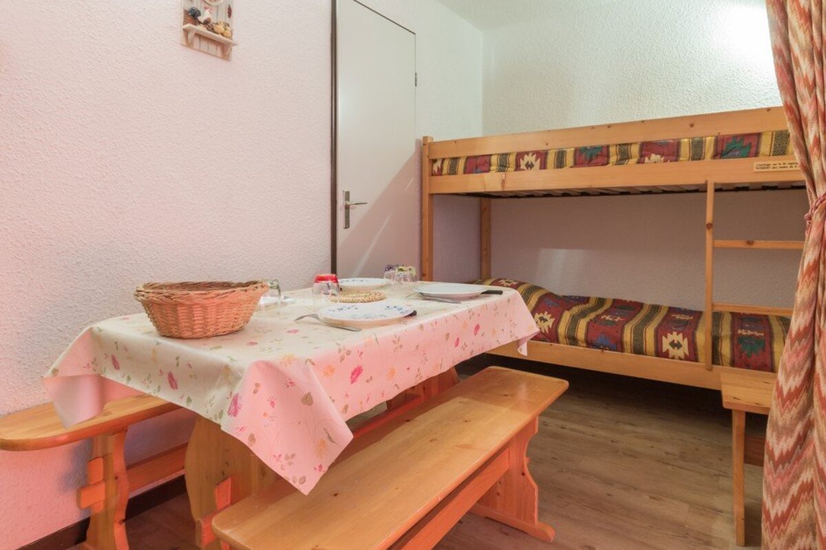 A room with a bunk bed and a table with plates on it