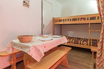 A room with a bunk bed and a table with plates on it