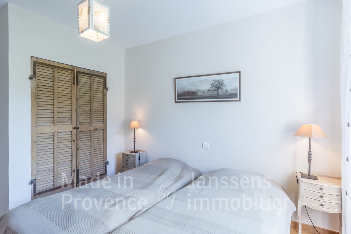 A bedroom with two beds made in provence by janssens immobilier