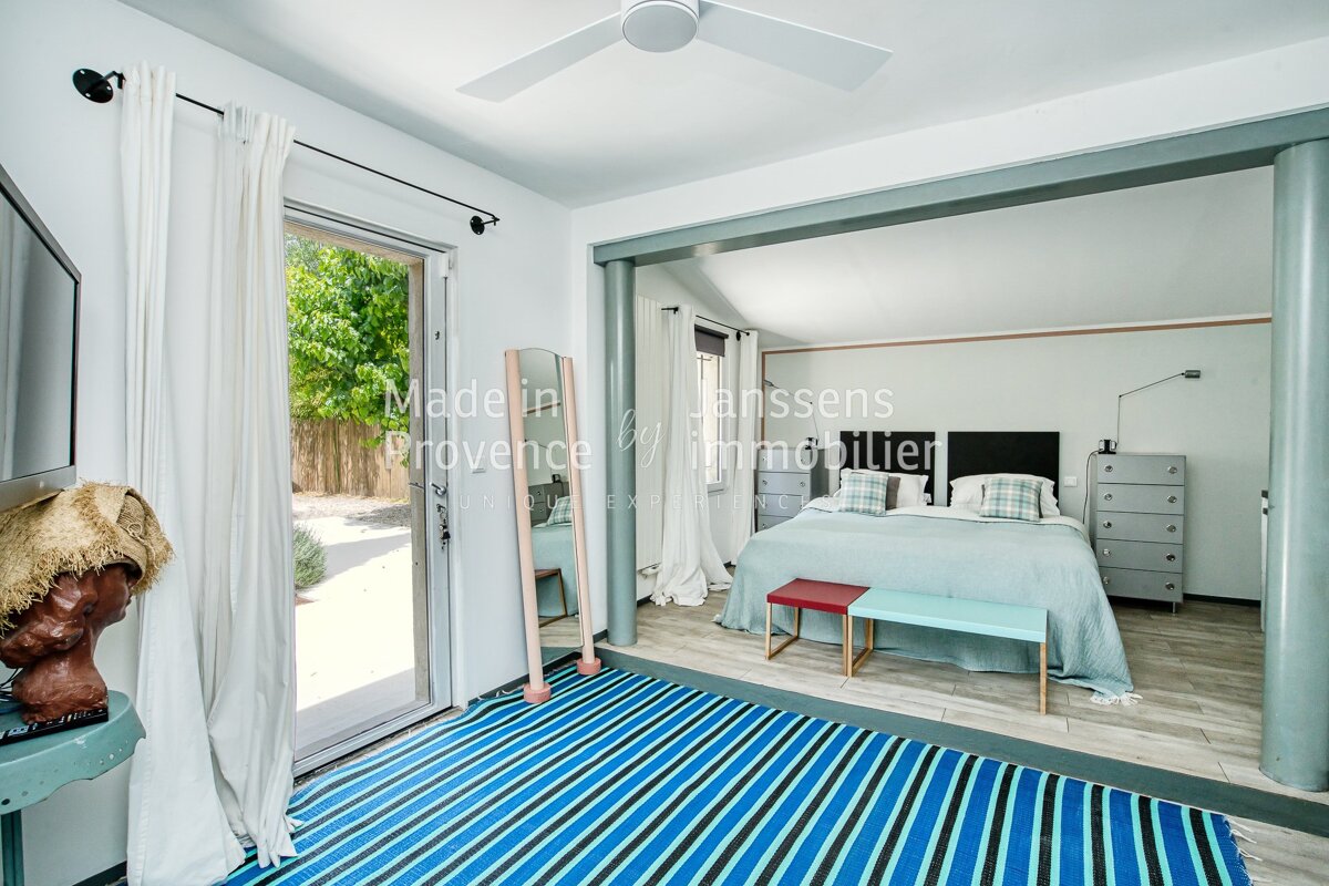A bedroom with a blue and white striped rug and the words made in provence on the wall