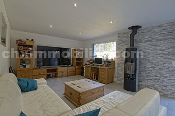 A living room with a large flat screen tv and a chimney with the website chimmobili.com in the corner