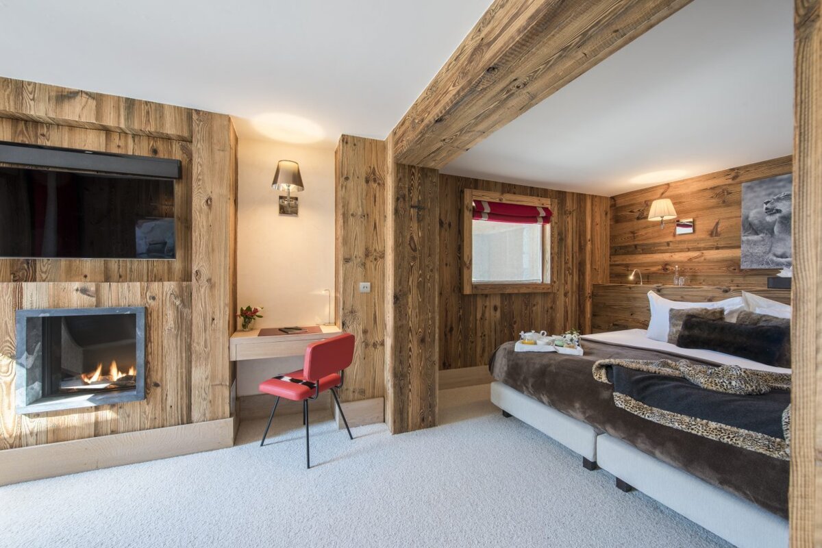 A bedroom with a large bed and a fireplace