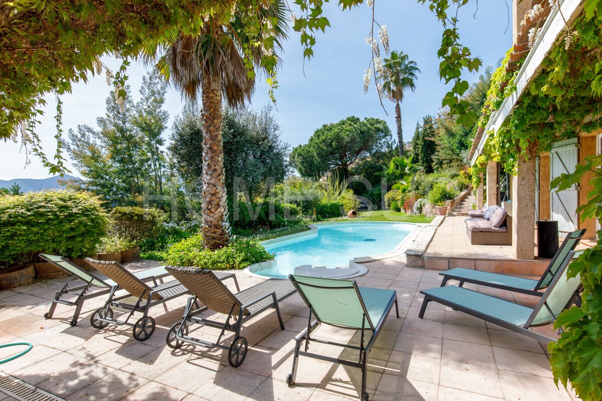 A swimming pool is surrounded by chairs and a sign that says home