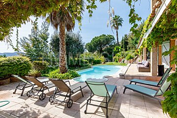 A swimming pool is surrounded by chairs and a sign that says home
