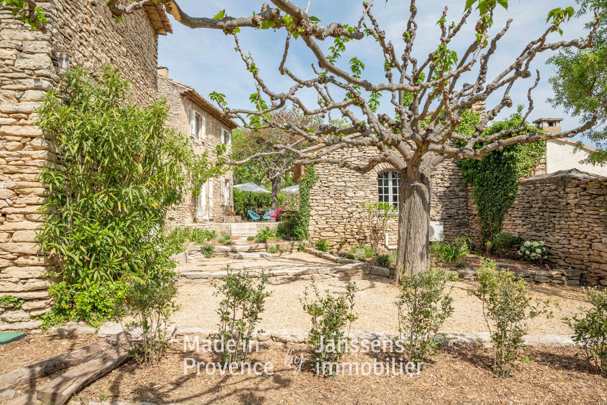 A tree in front of a stone building with the words made in provence at the bottom