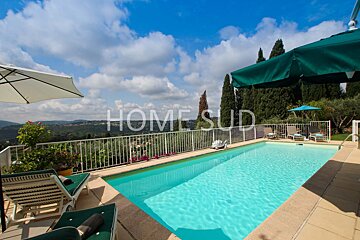 A large swimming pool surrounded by chairs and umbrellas is for sale by home sud