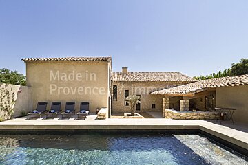 A swimming pool in front of a house that says made in provence