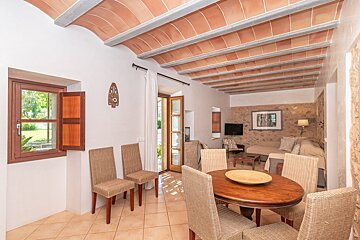 A living room with wicker chairs and a wooden table
