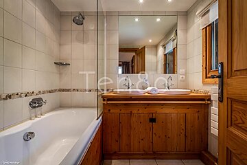 A bathroom with two sinks and a bathtub with the word terra on the wall