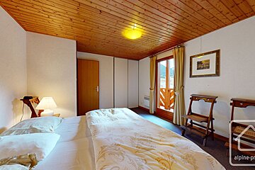 A bedroom with a bed and a picture on the wall that says alpine-pro