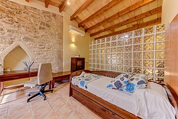 A bedroom with a bed a desk and a chair