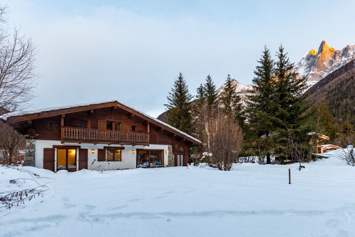 A house in the snow with a mountain in the background