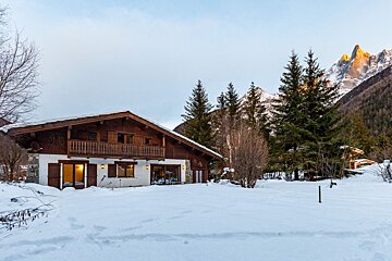 A house in the snow with a mountain in the background