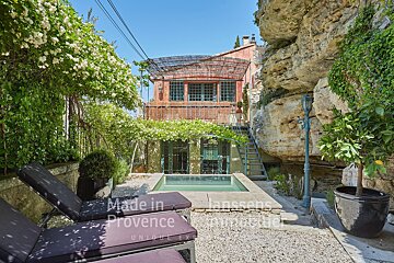 A swimming pool in front of a house that says made in provence