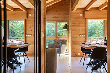 A wooden house with a dining table and chairs