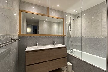 A bathroom with two sinks and a bathtub