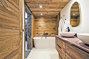 A bathroom with a bathtub and two sinks