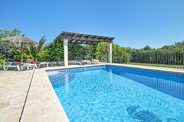 A swimming pool with a pergola and chairs around it