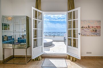 A room with a balcony and a painting on the wall