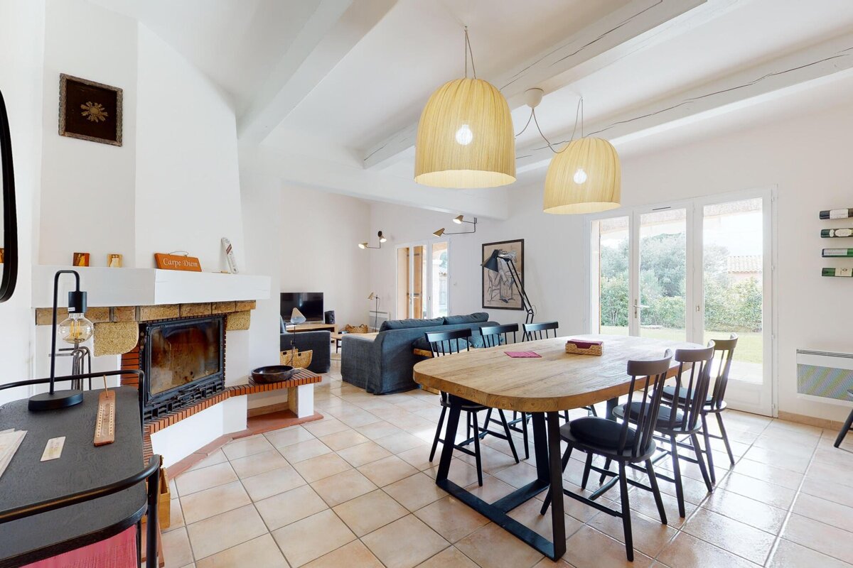 A living room with a table and chairs and a fireplace