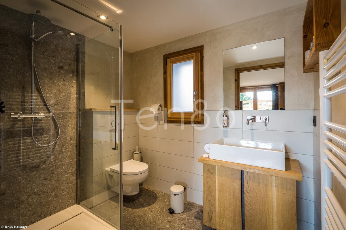 A bathroom with a toilet a sink and a shower with the word terra on the wall