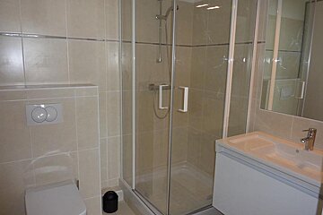 A bathroom with a toilet a sink and a shower