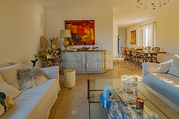 A living room with a couch a table and a painting on the wall that says provence immobilier
