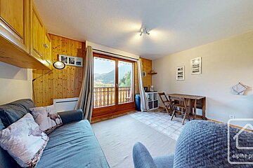 A living room with a couch and a table and a sign that says alpine-pro