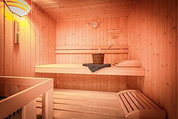 A wooden sauna with a bucket and a towel on the bench