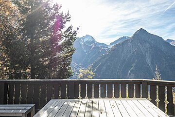 A balcony with a view of mountains and trees