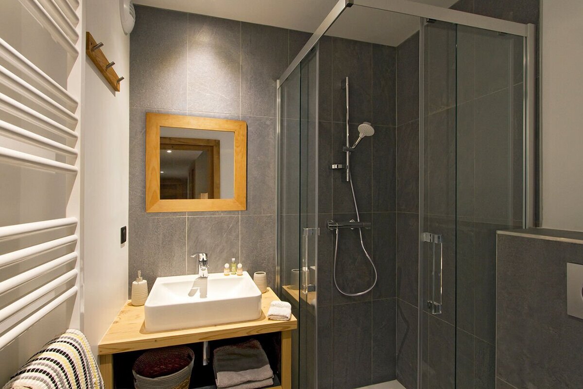 A bathroom with a sink a mirror and a shower